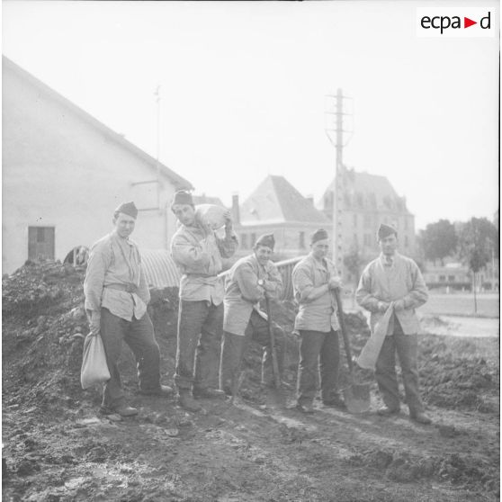 [Photographie de groupe d'une équipe du SCA (service cinématographique de l'armée) confectionnant des sacs de sable, Moulins-lès-Metz (Moselle), Septembre 1939.]