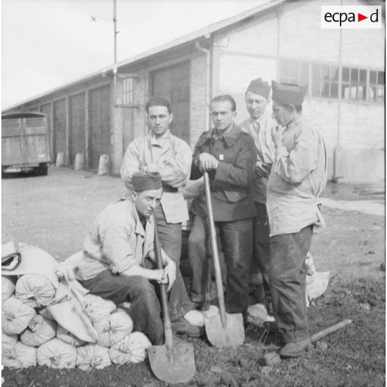 [Photographie de groupe d'une équipe du SCA (service cinématographique de l'armée) confectionnant des sacs de sable, Moulins-lès-Metz (Moselle), Septembre 1939.]