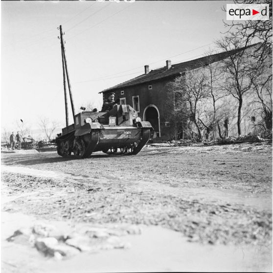 [Militaire anglais traversant un village sur une chenillette Carden-Loyd, s.d.]