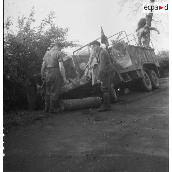 [Camion de transport de troupes renversé sur le bas côté de la route, s.d.]