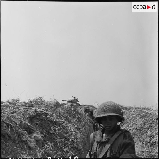 Des soldats dans une tranchée lors d'une contre-attaque appuyée par des blindés et l'aviation, au sud de Diên Biên Phu.