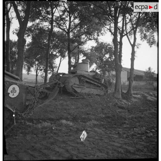 Des chars légers Renault FT 17 sont photographiés en plan général dans un bois bordant un champ.