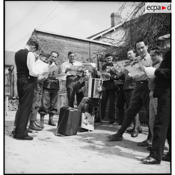 Photographie de groupe de soldats de la 2e armée qui chantent et jouent de l'accordéon.