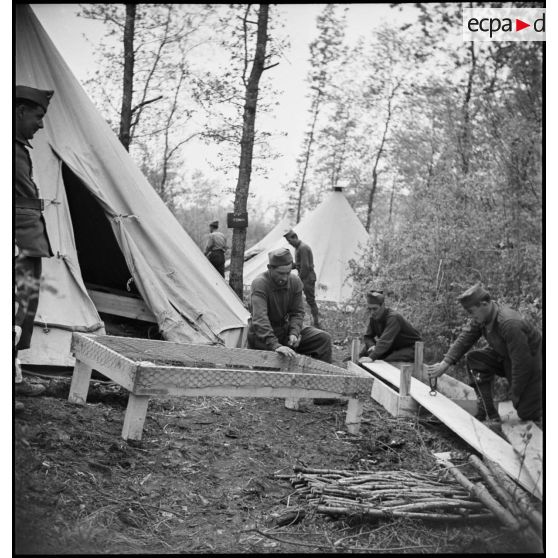 Dans le cantonnement des soldats de la 2e armée fabriquent des sommiers.