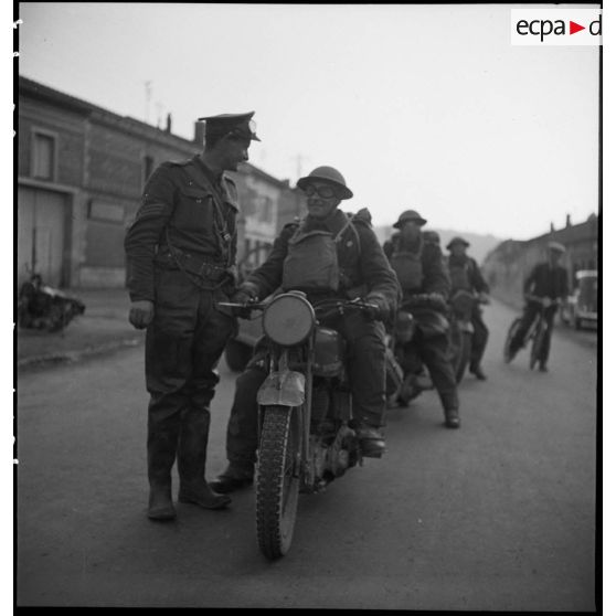 A l'arrêt, des motocyclistes de la BEF sont photographiés en colonne dans un village du secteur de la 2e armée.