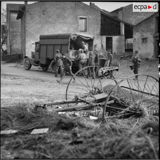 Dans un village de Moselle des soldats déchargent un camion.