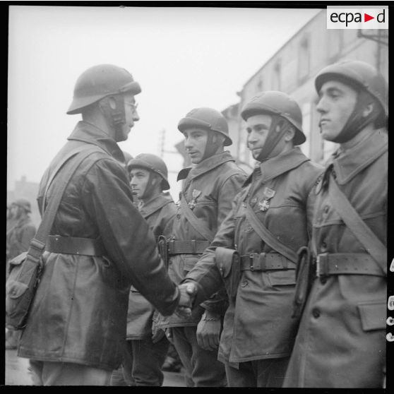 Le chef de corps décore de la croix de guerre 1939 des hommes de son bataillon lors de la prise d'armes à Magny.