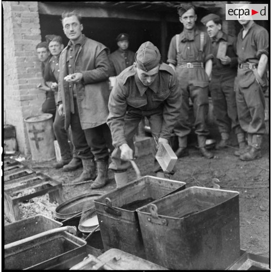 Photographie de groupe de soldats de la 51e DI (BEF) près de gamelles pleines.