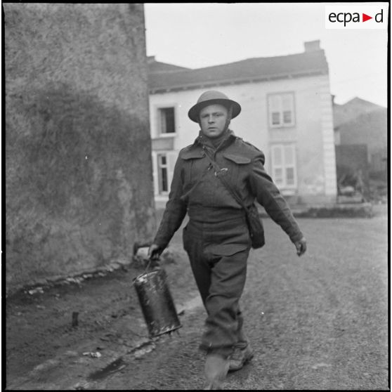 Un soldat de la 51e DI (BEF) est photographié en plan américain dans un village de Moselle (zone de la 3e armée).