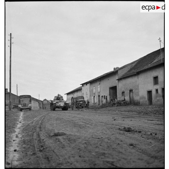 Un char Renault R35 du 5e BCC roule dans une rue d'un village de Moselle.