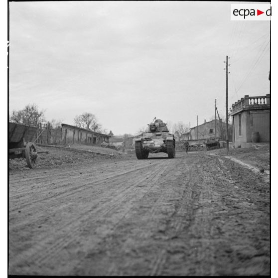 Un char Renault R35 du 5e BCC roule dans une rue d'un village de Moselle.