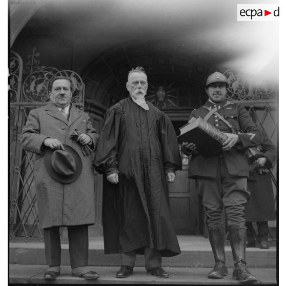 Devant un temple un pasteur et un gendarme sont photographiés une bible en main dans le secteur de la 5e armée.