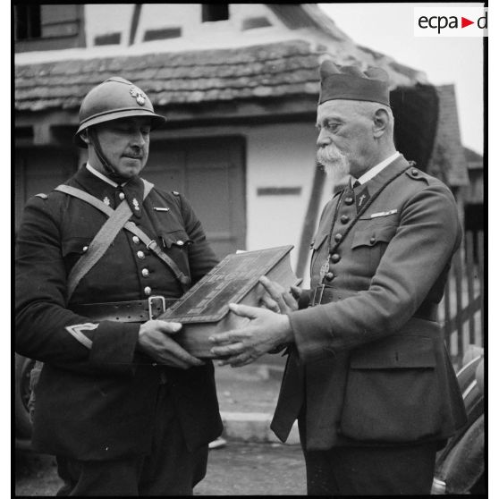 Devant un temple un pasteur et un gendarme sont photographiés une bible en main dans le secteur de la 5e armée.