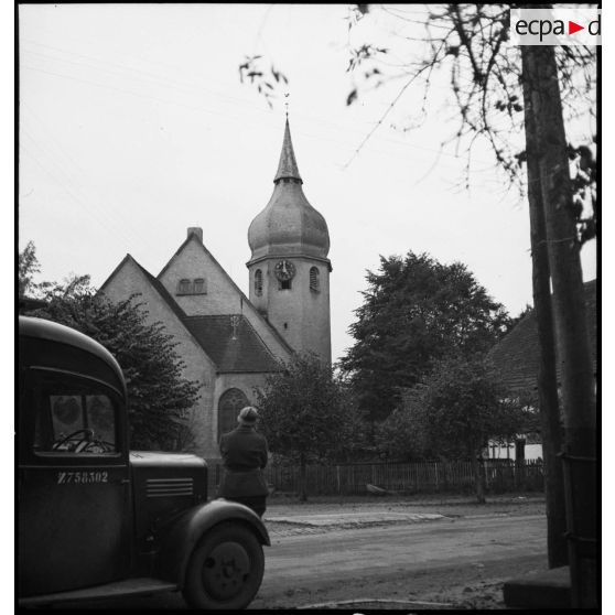 Un caméraman du service cinématographique de l'armée (SCA) filme l'église protestante de Sessenheim (Bas-Rhin).