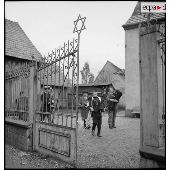 Devant une synagogue un aumônier militaire de confession juive évacue les tables de la Loi aidé de gendarmes.