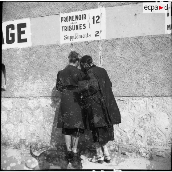 Deux femmes sont photographiées de dos à l'entrée du stade d'Antibes.