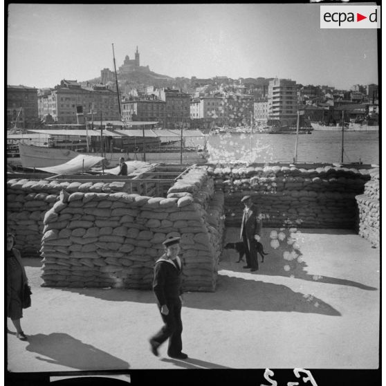 Plan général du vieux port de Marseille avec au premier plan des sacs de sable en protection.