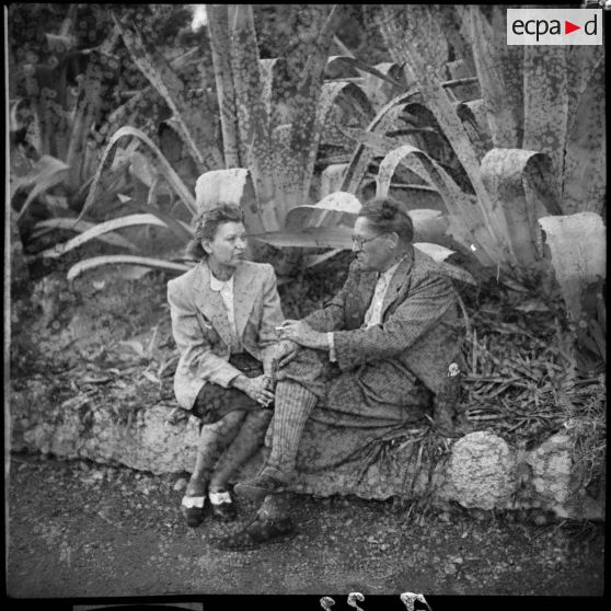 Un homme et une femme discutent assis sur un banc.