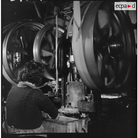 Dans un atelier l'usine de Valence, une ouvrière travaille sur une machine-outil.