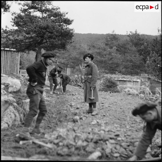 Des chasseurs du 9e BCA travaillent à l'amélioration du campament en effectuant des travaux de terrassement.