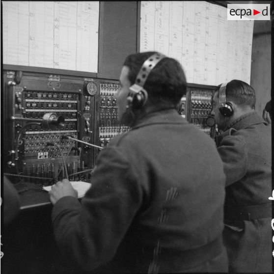 Des soldats utilisent des appareils de transmissionss dans un central téléphonique.