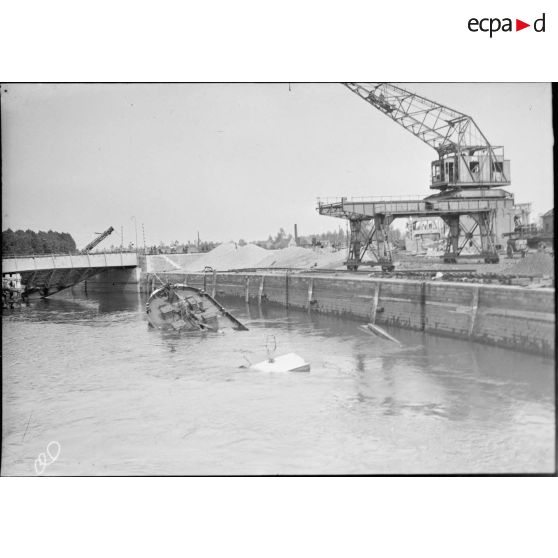 Un bateau et divers bâtiment en ruines dans le secteur de la 7e armée.