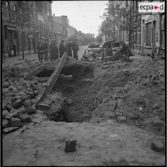 Des civils discutent dans une rue en ruine.