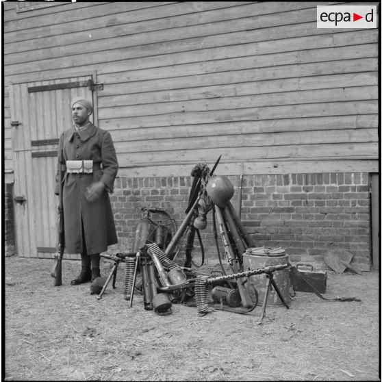 Un tirailleur marocain pose au côté d'une "prise de guerre" sur du matériel allemand.