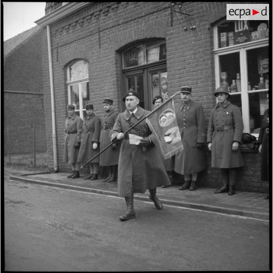 Capitaine s'avancant avec le fanion de la 9e batterie du 6e RA (régiment d'artillerie).