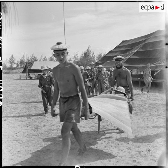 Au cours d'un échange de prisonniers des forces françaises et du Viêt-minh à Thanh Hoa, des marins brancardent des prisonniers français invalides.