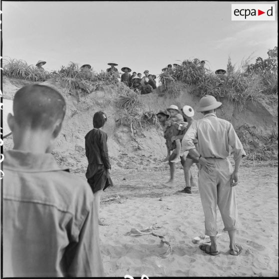 Au cours d'un échange de prisonniers des forces françaises et du Viêt-minh à Thanh Hoa, un prisonnier français est porté sur le dos d'un de ses camarades pour rejoindre le lieu d'embarquement.