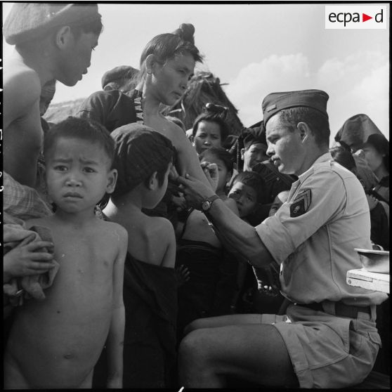 Vaccination d'une femme Thaï par un sergent du Service de santé dans un village de la vallée de Diên Bien Phu.