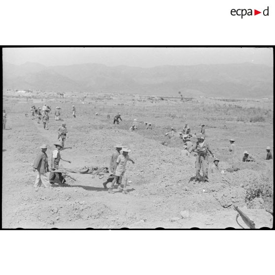 Des soldats creusent des tombes pour enterrer les morts sur le piton Isabelle du camp retranché de Diên Biên Phu.