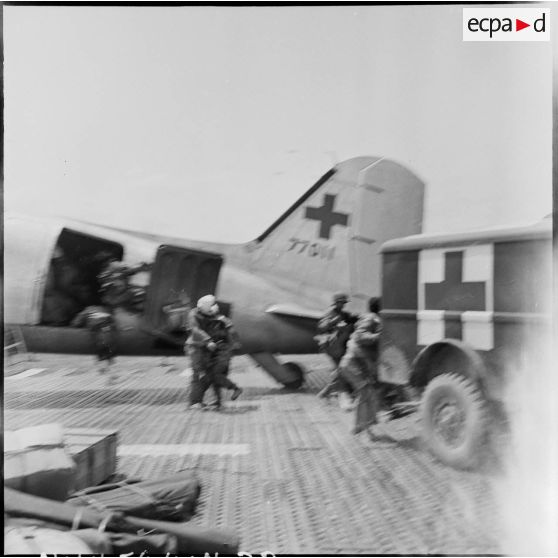 Embarquement de blessés à bord d'un avion Douglas C-47B skytrain (Dakota) au cours d'une évacuation sanitaire à Diên Biên Phu.