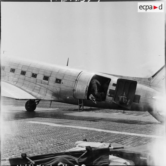 Embarquement de blessés à bord d'un avion Douglas C-47B skytrain (Dakota) au cours d'une évacuation sanitaire à Diên Biên Phu.