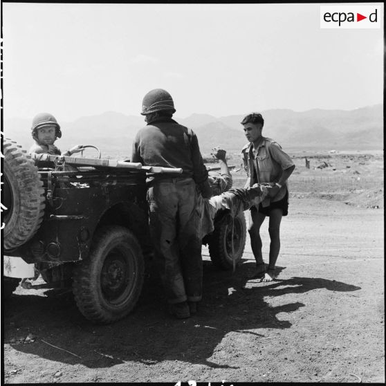 Depuis le centre de résistance Isabelle, évacuation de blessés à bord d'une jeep sur laquelle les brancards sont  posés. Le photographe du SPI (Service presse information) Jean Péraud a pris le volant.