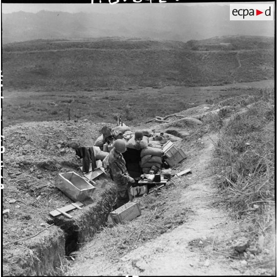 Un soldat vérifie son paquetage devant un abri fortifié du camp retranché de Diên Biên Phu.