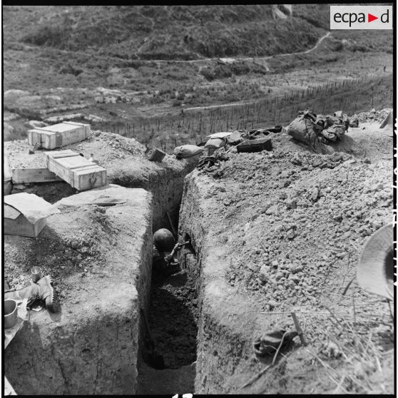 Soldat creusant à Diên Biên Phu une cavité dans la paroi d'une tranchée à des fins de rangement.