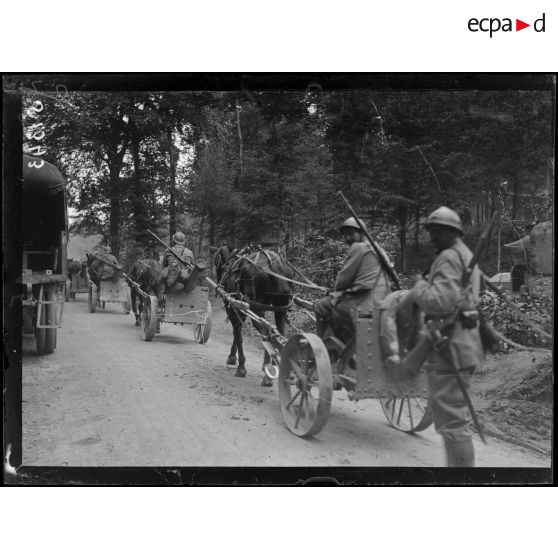 Canons de tranchées montés sur roues et traînés par des chevaux défilant dans le Bois l'Abbé. [légende d'origine]