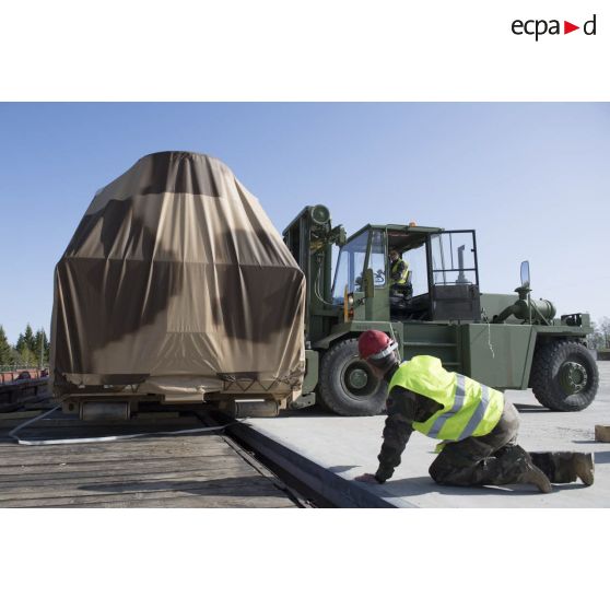 Des logisticiens du 503e régiment du train (503e RT) déchargent un abri modulaire déployable (AMD) à l'aide d'un chariot élévateur Valmet depuis un train à Tapa, en Estonie.