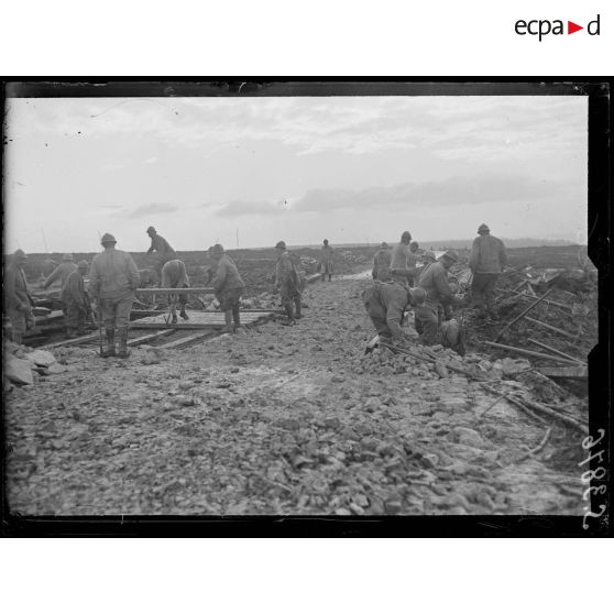 Entre Aizy et l'Ange Gardien (Aisne). Réfection de la route de Maubeuge. Le remplacement d'un plaquage en bois d'une route par des pierres. [légende d'origine]