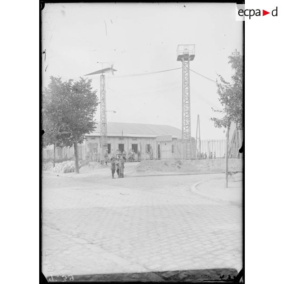 30 Juillet 1915. Le Bourget. Poste de l'entrée du parc, à gauche le pylône portant la flèche de toile indicatrice de la direction des vents, à droite, celui portant le phare Zutcher, à feux intermittents. [légende d'origine]