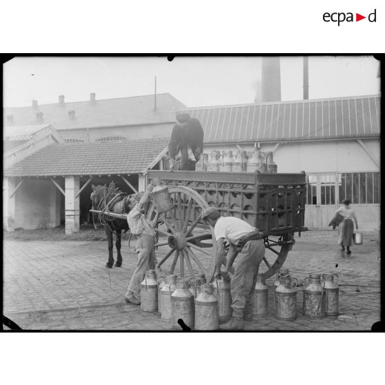 Parc de l'usine de produits chimiques de Croissy. Le lait est chargé en voiture pour être vendu au commerce. [légende d'origine]