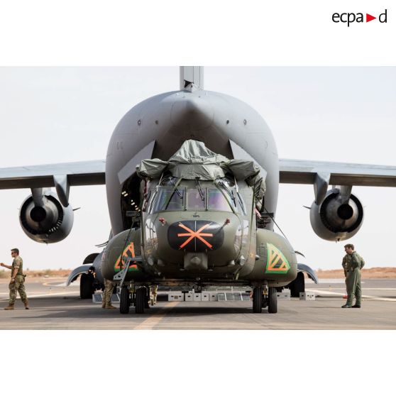 Déchargement d'un hélicoptère Chinook CH-47 par le personnel britannique depuis la soute d'un avion cargo douglas C-17 de la Royal Air Force en stationnement sur la piste de l'aéroport de Gao.