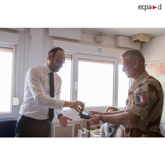 Echange de cadeaux entre le Premier ministre Edouard Philippe et le général de division Frédéric Blachon, commandant la force Barkhane, lors de sa visite sur la PFOD (plateforme opérationnelle désert) de Gao.