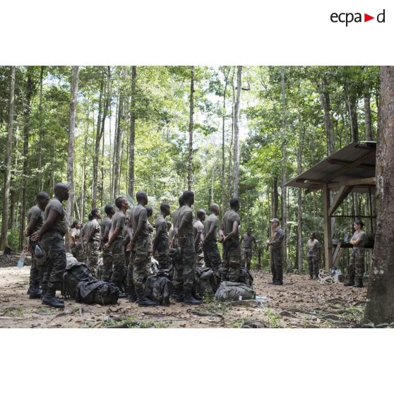 Des stagiaires écoutent un briefing lors d'un atelier bivouac à Saint-Jean-du-Maroni, en Guyane française.