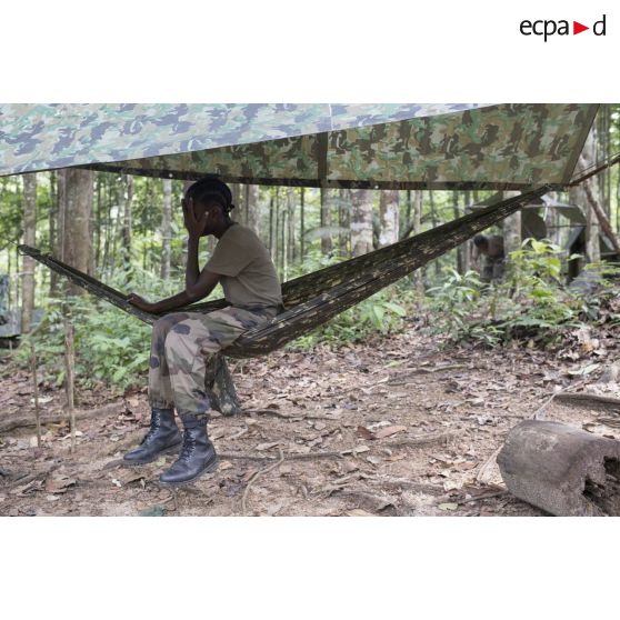 Une stagiaire du régiment du service militaire adapté (RSMA) teste son hamac pour le montage d'un bivouac lors d'un atelier jungle à Saint-Jean-du-Maroni, en Guyane française.