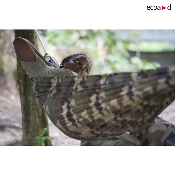 Une stagiaire du régiment du service militaire adapté (RSMA) teste son hamac pour le montage d'un bivouac lors d'un atelier jungle à Saint-Jean-du-Maroni, en Guyane française.