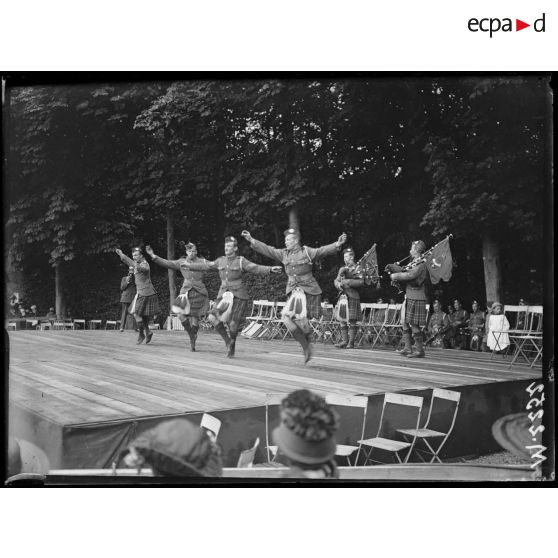 La musique militaire écossaise en représentation dans la cour de Versaille. Des danseurs écossais participent à un spectacle donné dans les jardins du château. [légende d'origine]