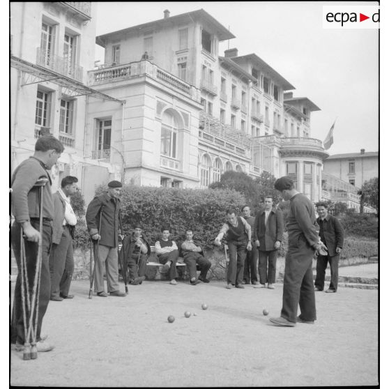 Des soldats blessés ou en convalescence disputent une partie de pétanque dans les jardins de l'hôpital du Mont des oiseaux.